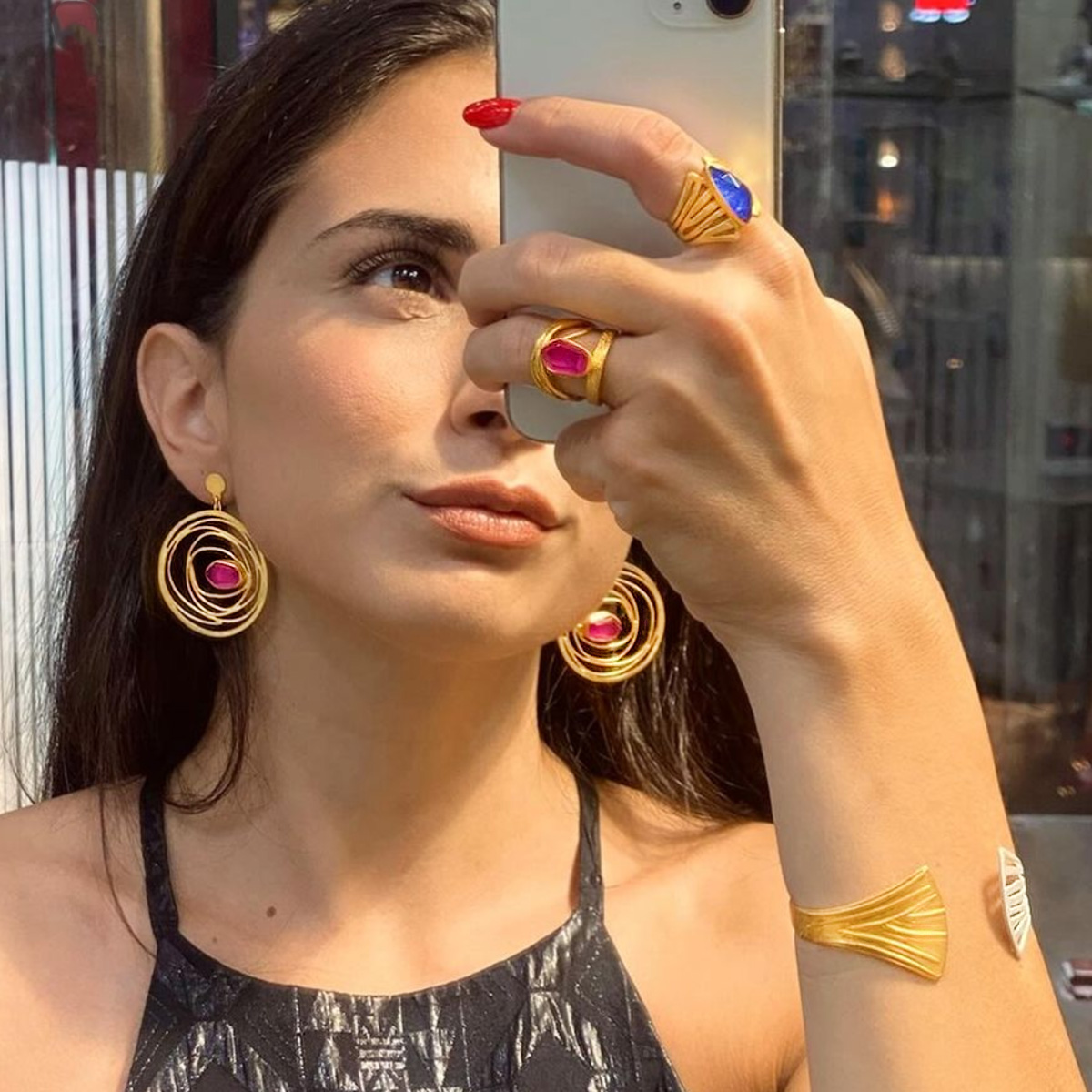 model wearing jewelry sodalite ring, red corundum ring & earrings, cuff bracelet, lapis